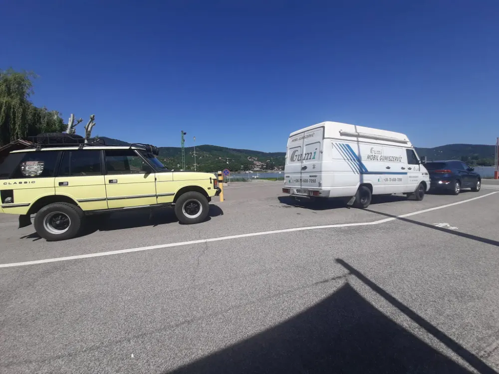 A szervizbusz egy Duna-parti parkolóban, a háttérben a folyó és a dunakanyari hegyek.